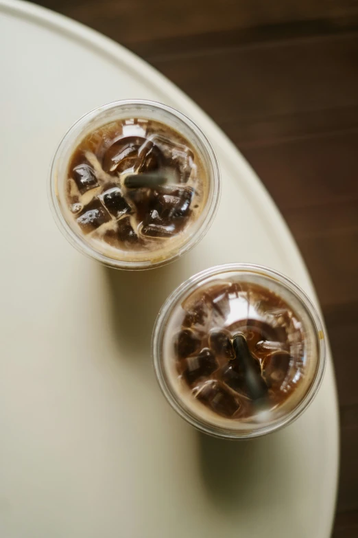 two drink glasses filled with ice and chocolate syrup