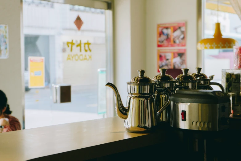 there is a pot and two coffeepots on the counter