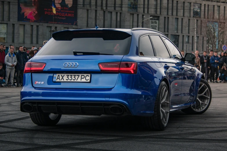 an audi rs3 coupe on street with people watching