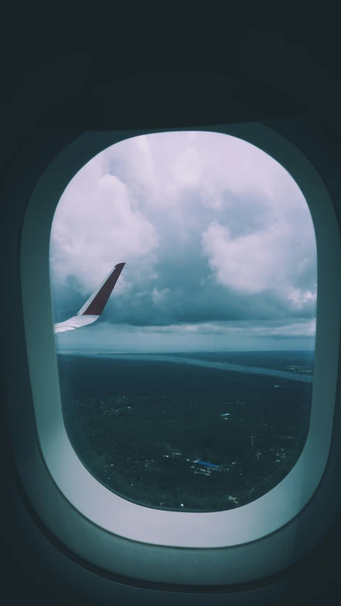 looking out an airplane window at a dark stormy sky