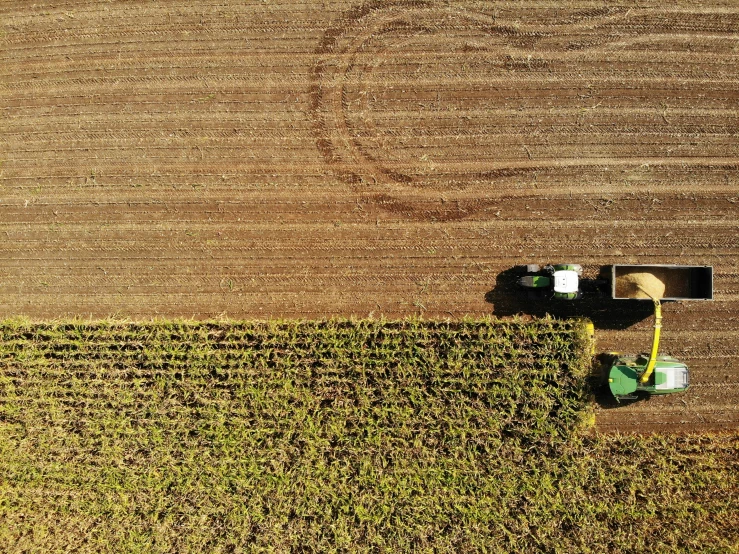 two tractors plowing a field using machinery