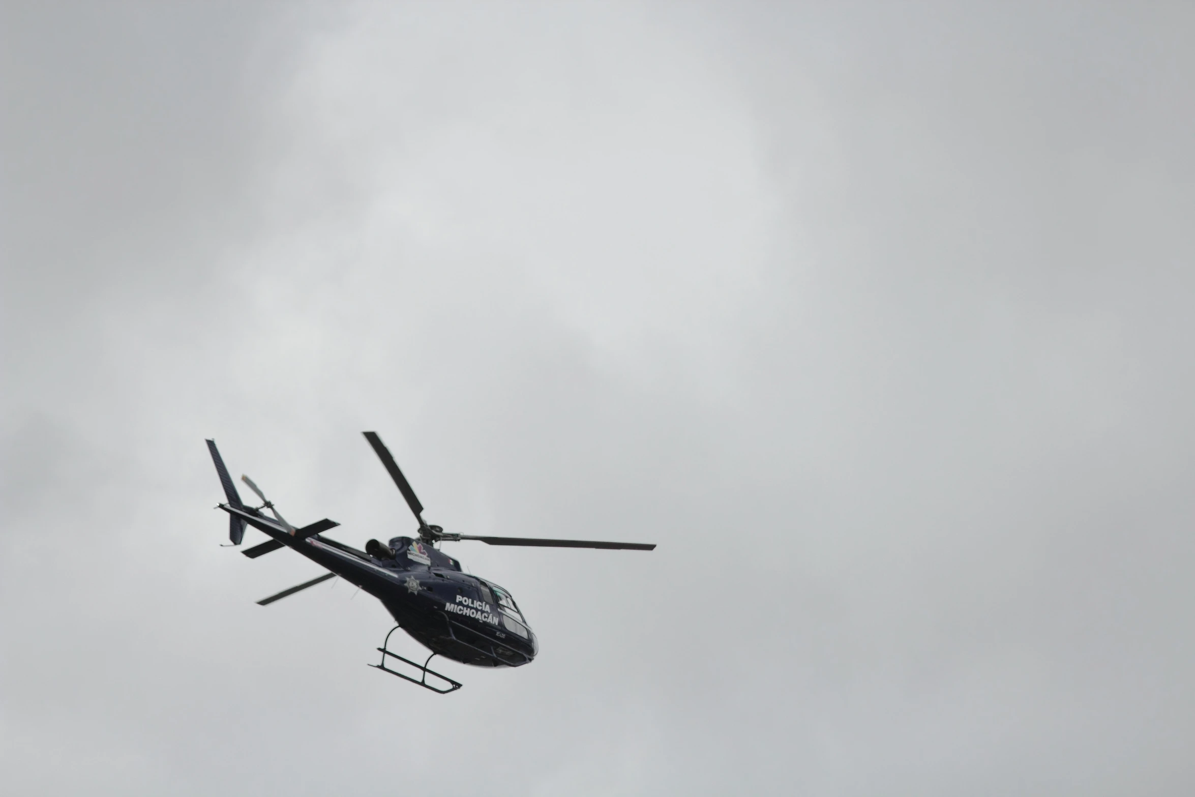 a helicopter flying in the air on a cloudy day