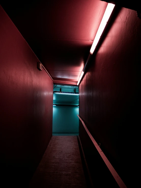 a very dark corridor with a green and red light