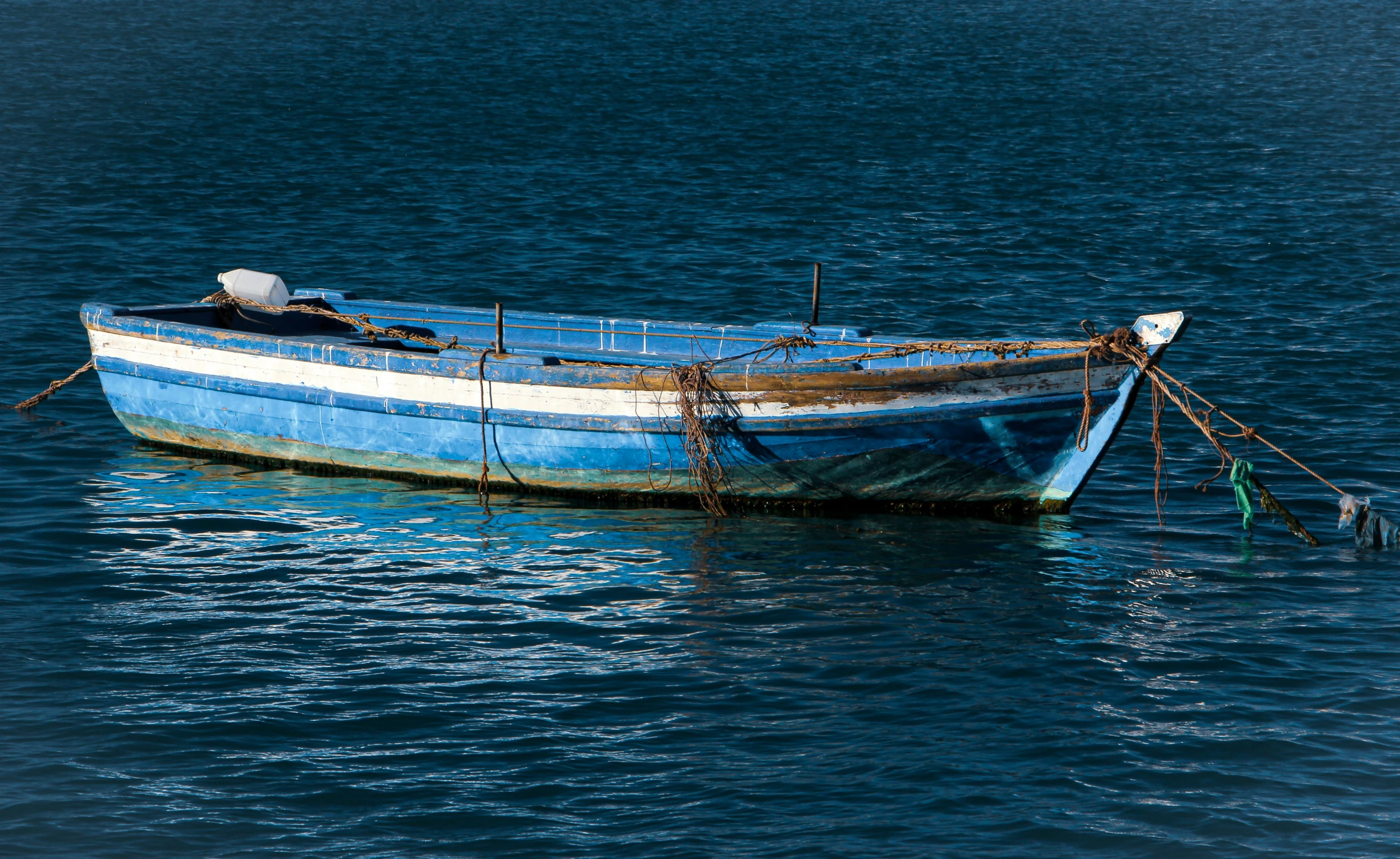 a blue boat with rope tied on it
