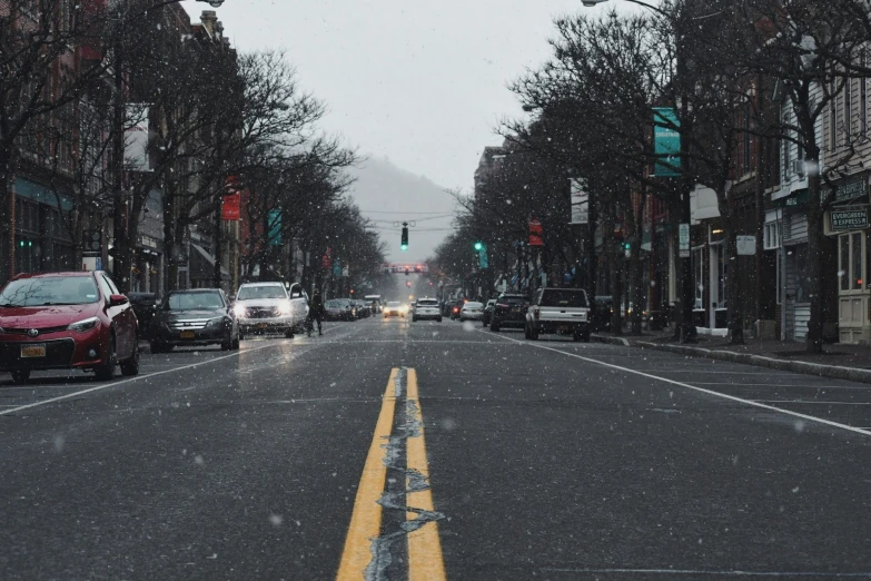 a road in the middle of town is covered in snow