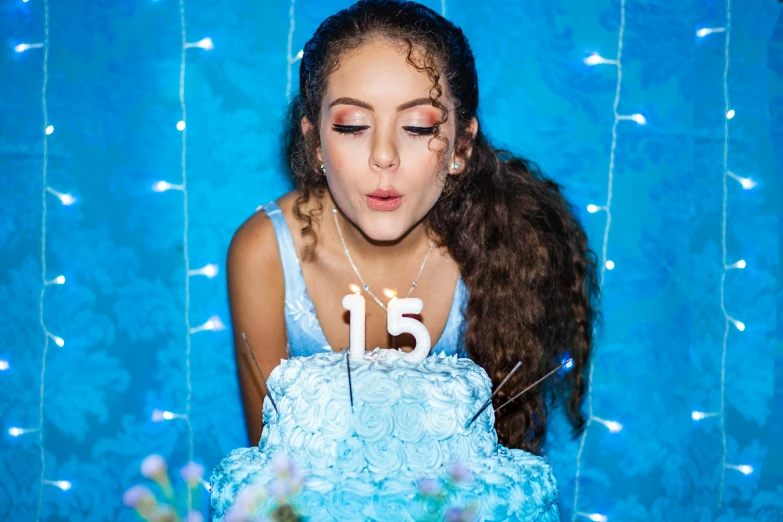 girl blowing out birthday candles on cake in po booth