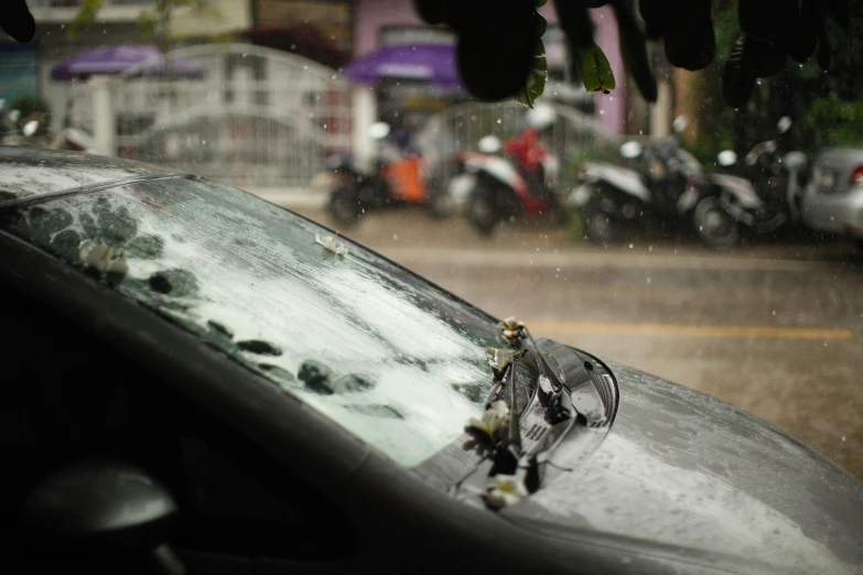 a rain soaked car with several bikes parked along the curb