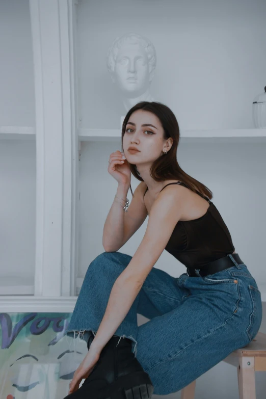 a woman sitting on the floor holding up her left hand