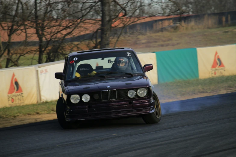 a car driving down the track with it's front windshield blown off