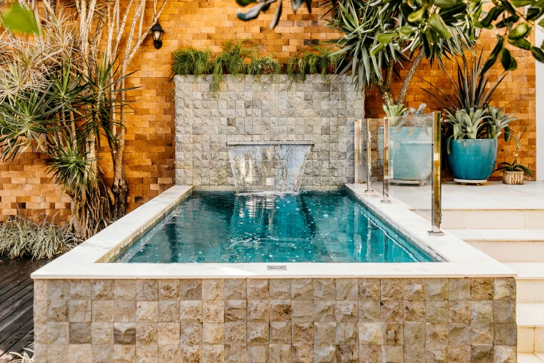 a swimming pool with a waterfall built in stone