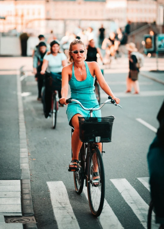 a woman wearing sunglasses and riding a bike on the street