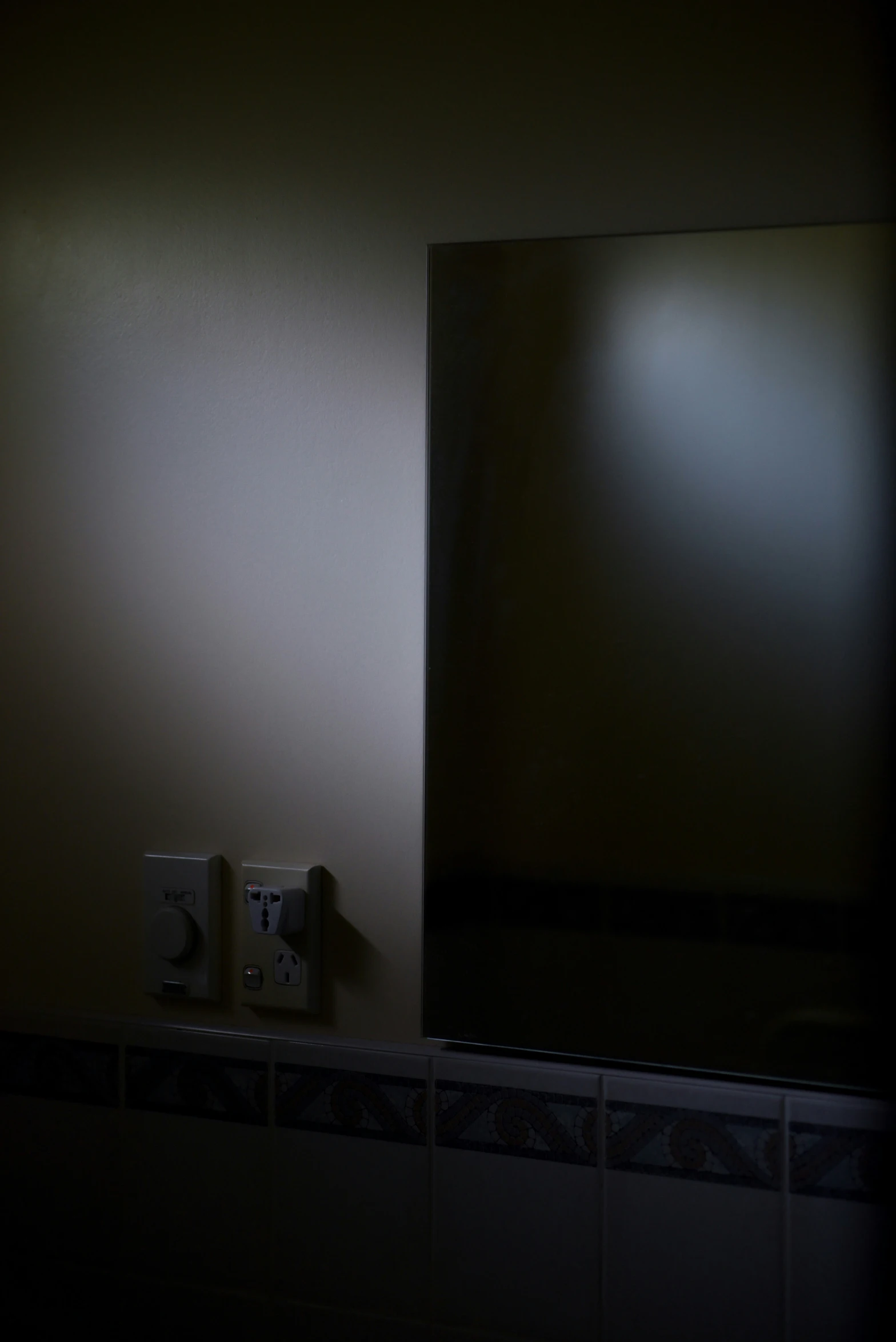 a dimly lit mirror in a dark room