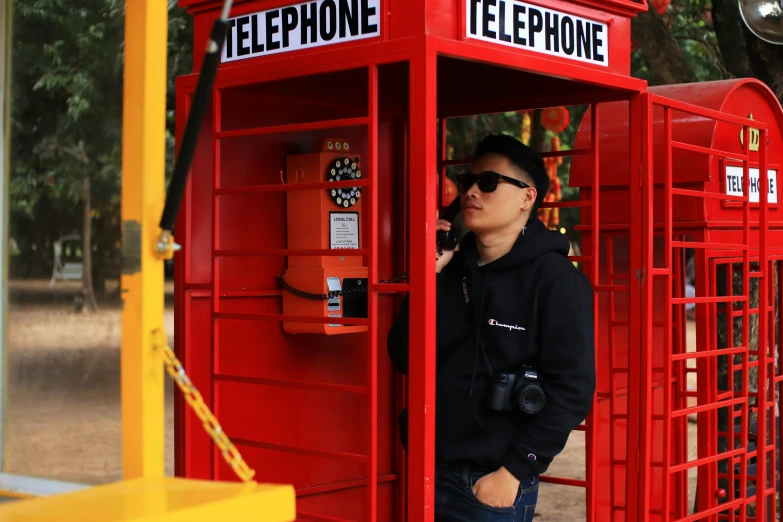 a man standing in front of an electronic telephone booth