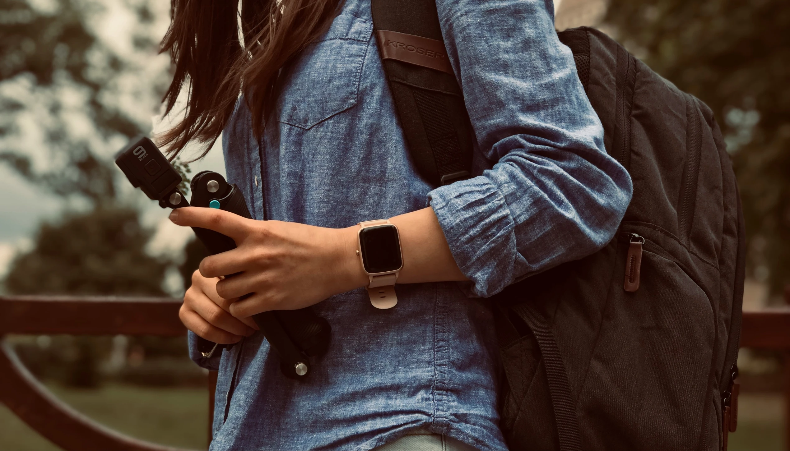 a woman walking with a camera strapped on her shoulder