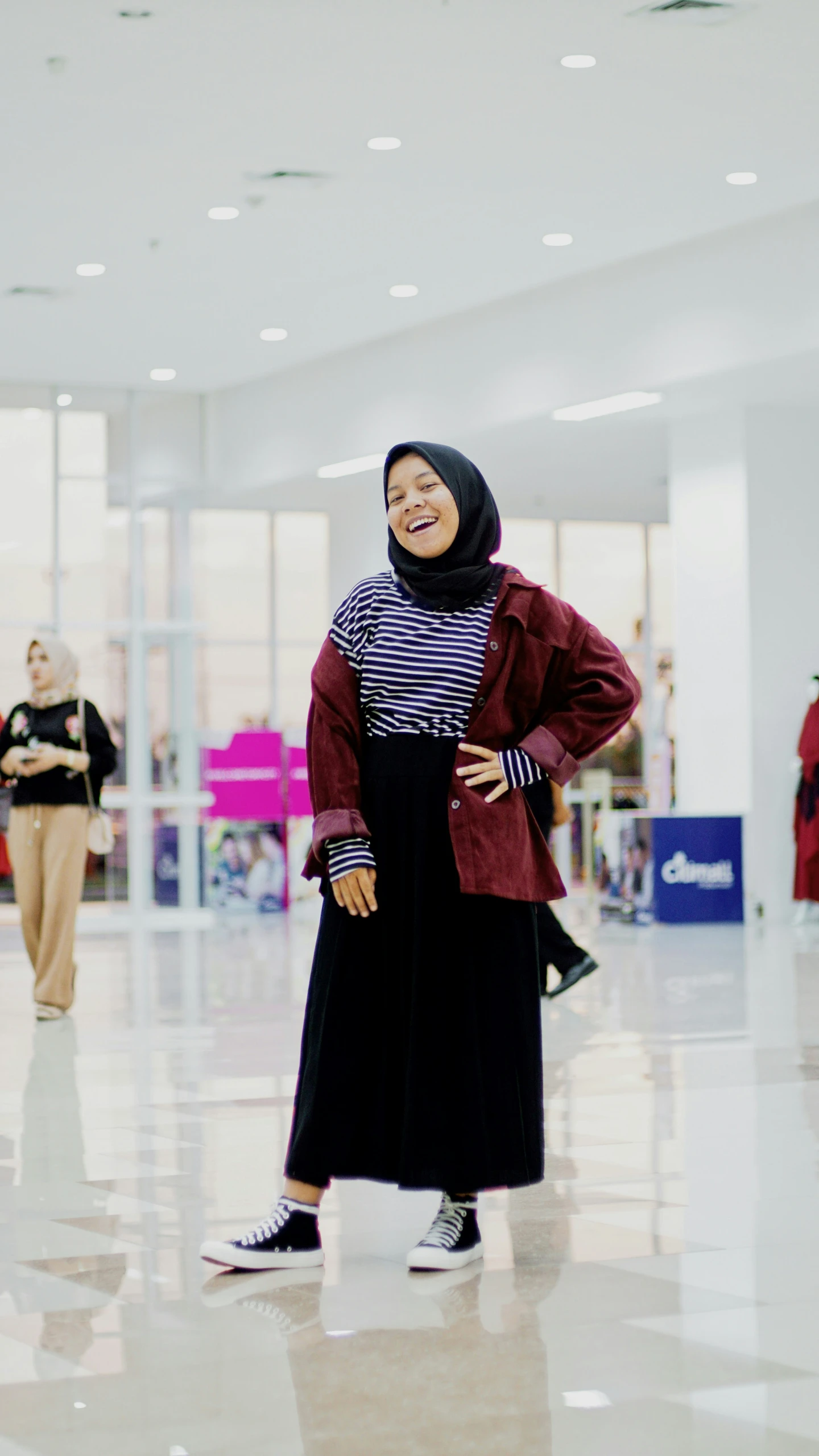 woman in long coat standing in large lobby