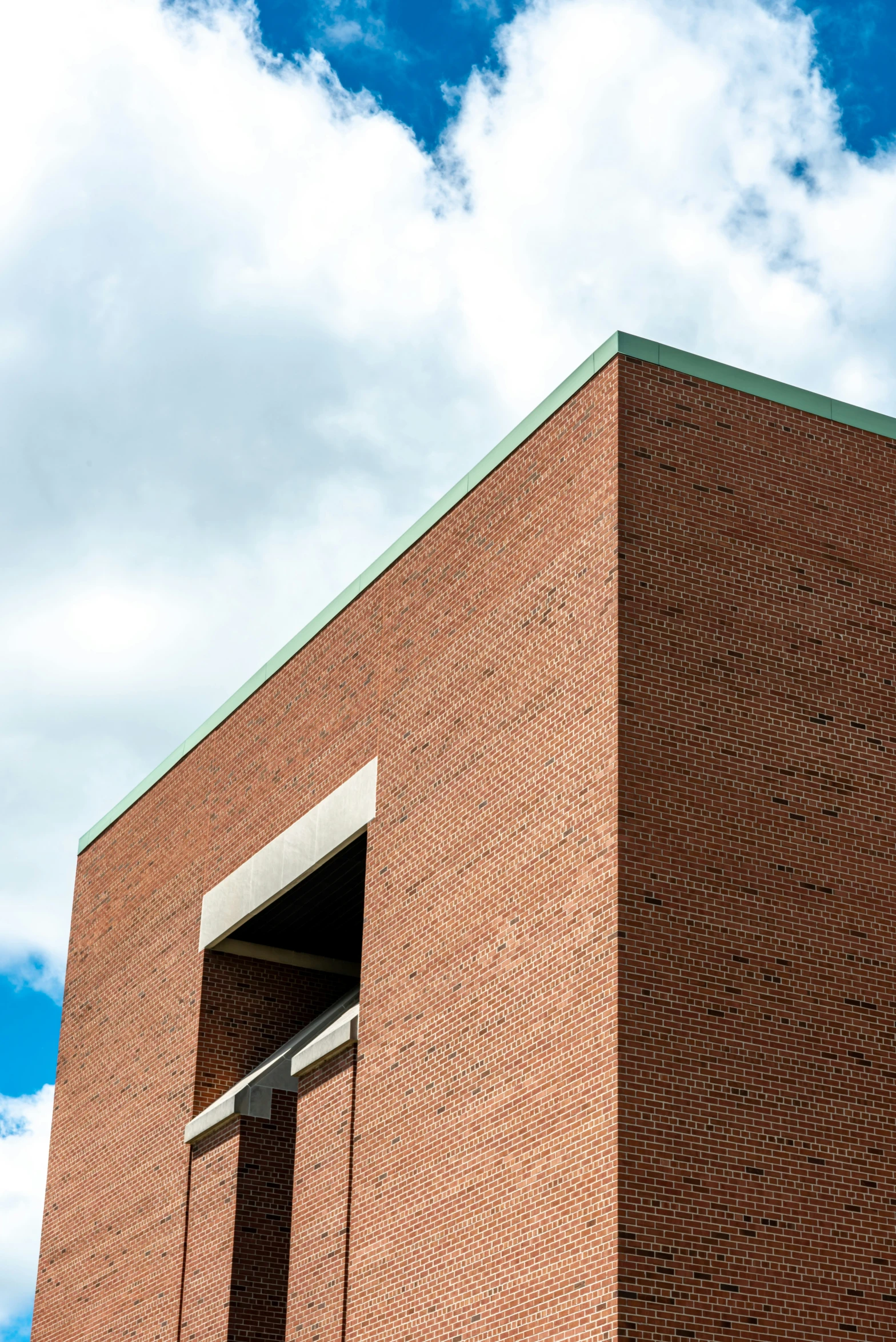 an angled brick building with a sky background