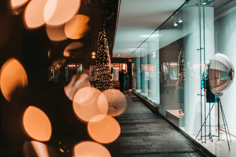 a christmas tree is lit in front of a glass window