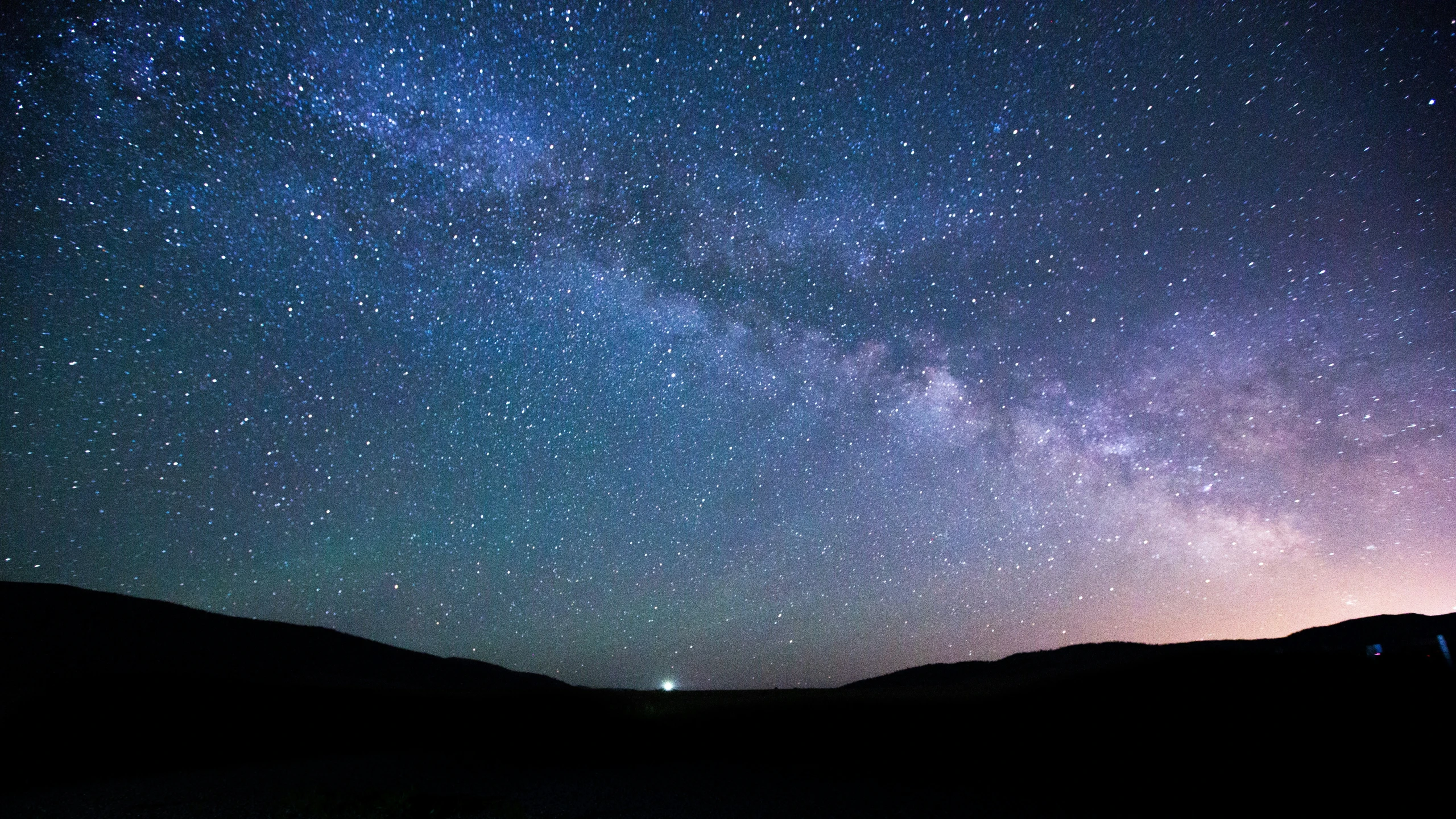 a hill that has a sky full of stars on it