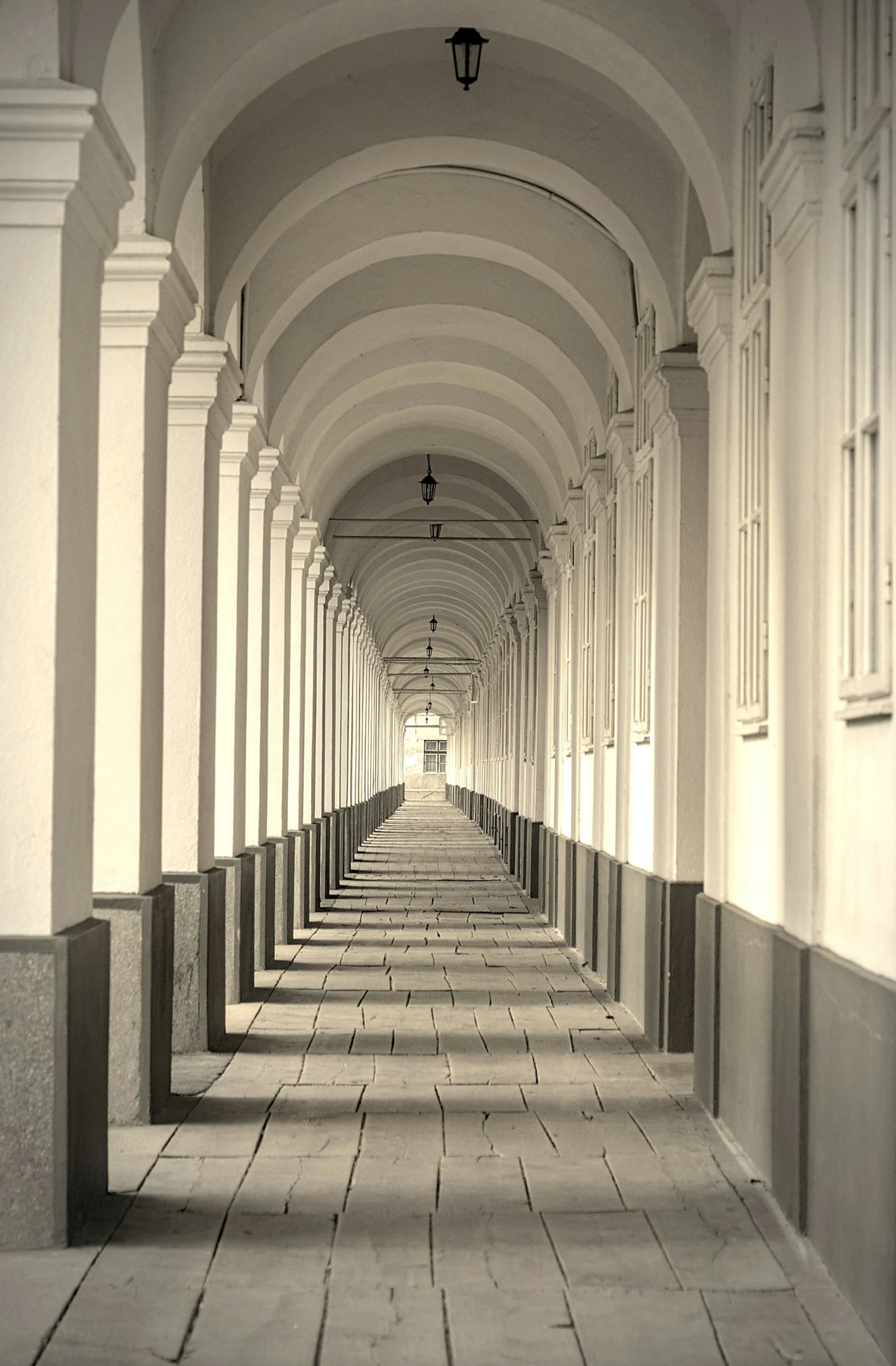 an empty corridor that has pillars leading into the room