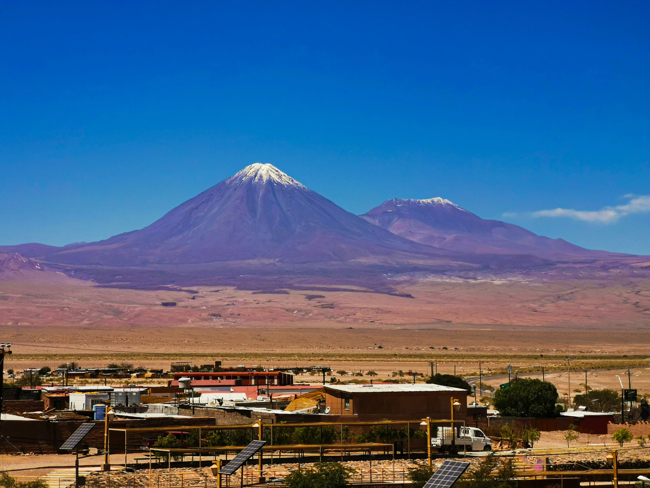 a mountain is shown above some buildings in the desert