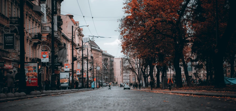 a dark street with buildings and trees on each side