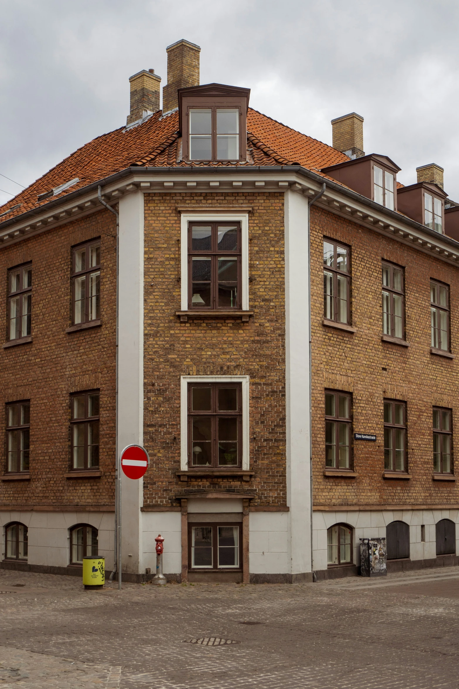 old building that houses a car and some parking meters in front of it