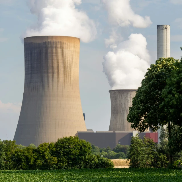 a factory emitting steam is towering into the sky