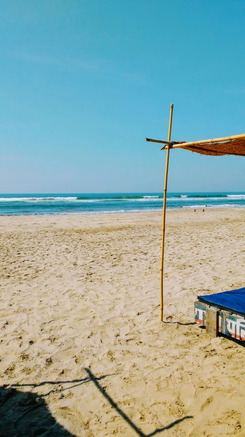 a beach covered in sand with a few umbrellas