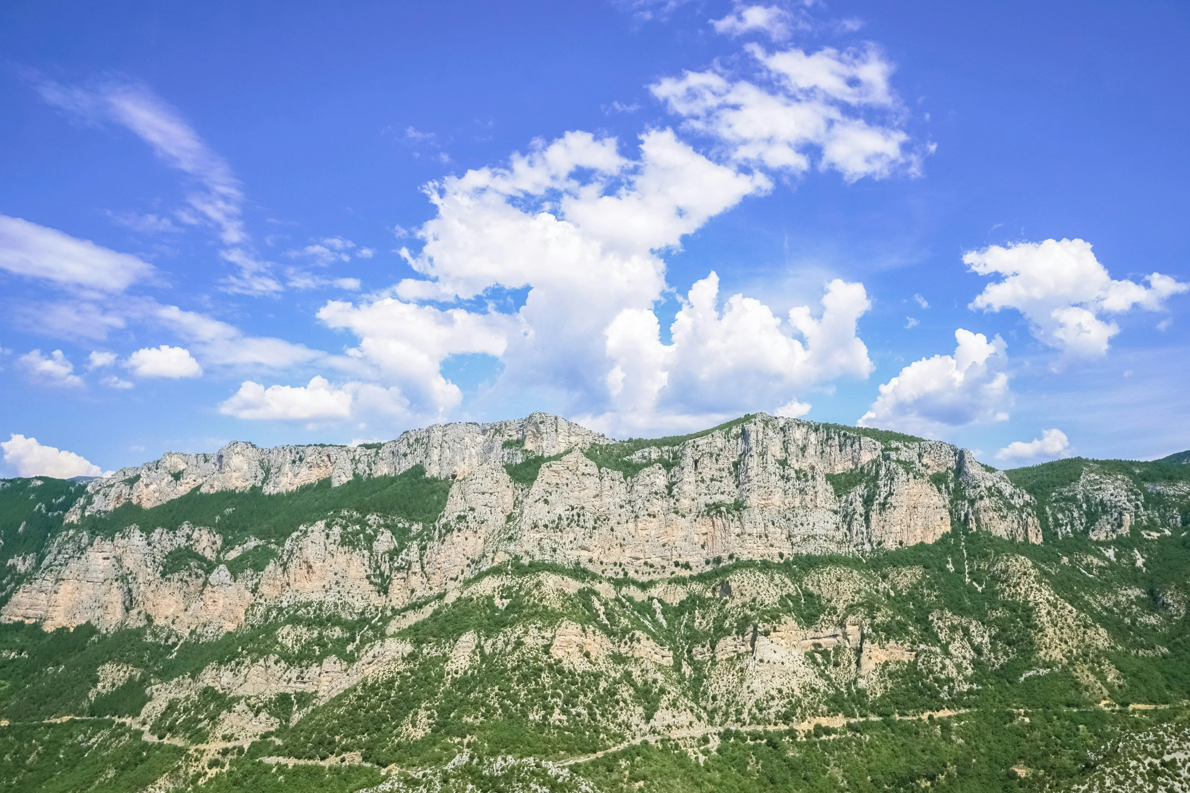 there are many hills near the grass on the mountainside