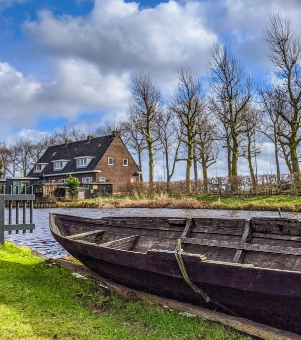 three boats in a yard with houses in the background