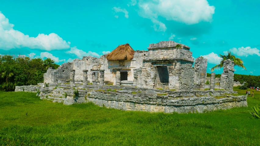 a stone structure with grass on the ground