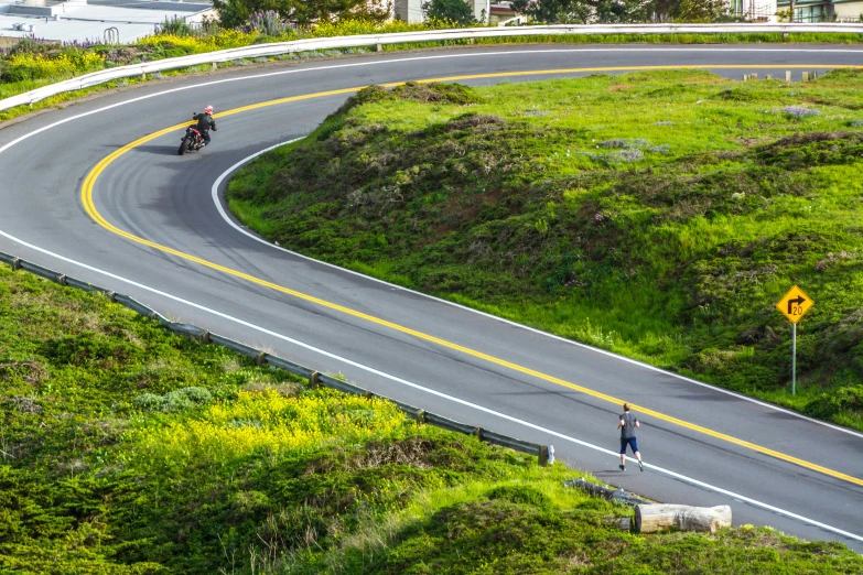 people riding on the side of a curvy road