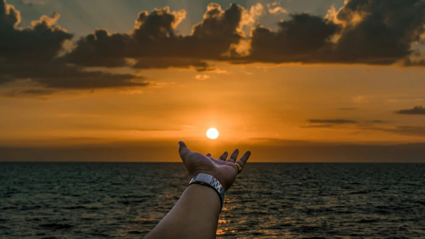 a person is standing on a boat in the water at sunset