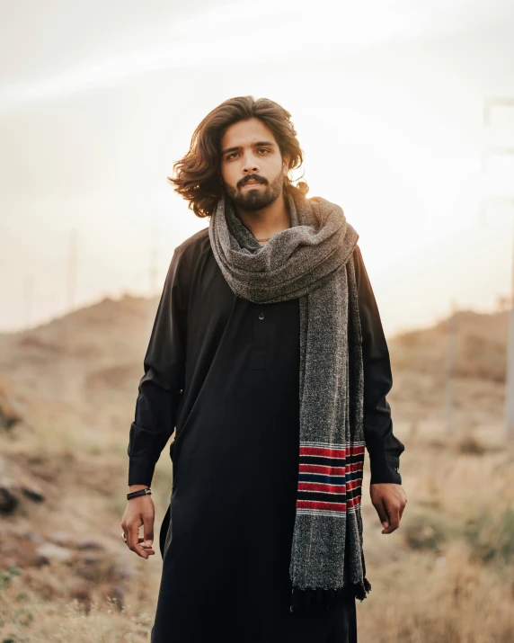 a man in black with a scarf and scarf on