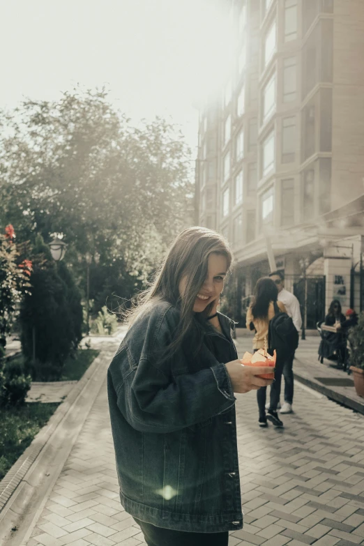 a woman standing on a brick walkway holding a cell phone to her ear