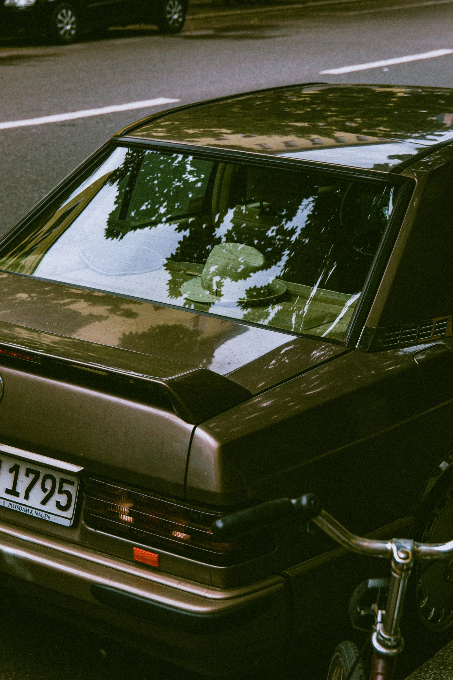 an older model parked beside a street with parked cars