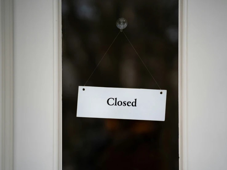 a closed sign hanging from a clear door