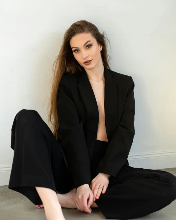 a girl posing for a po in a black suit