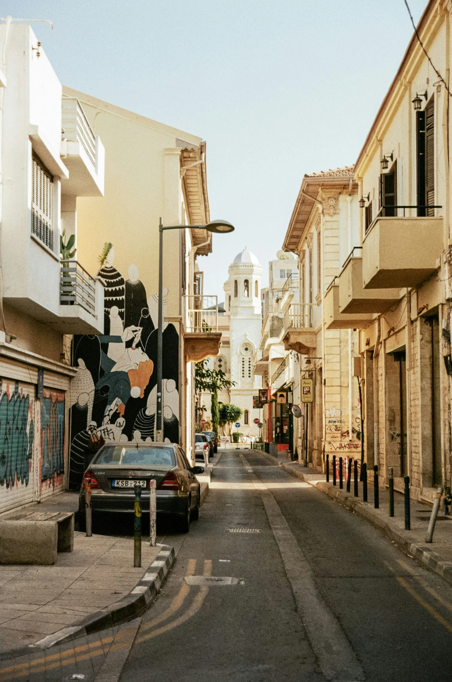 an empty street in an urban setting with cars parked