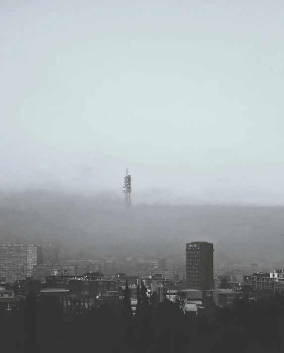 a large tall building next to a city skyline