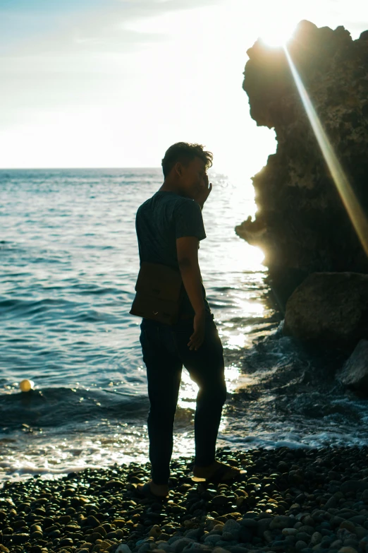 man standing on beach next to body of water