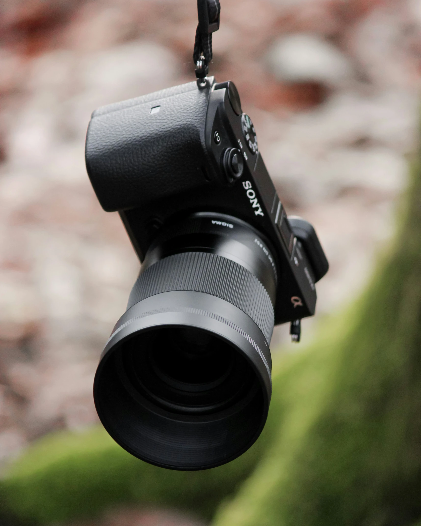 a camera with the lens and accessory hanging off a shoulder