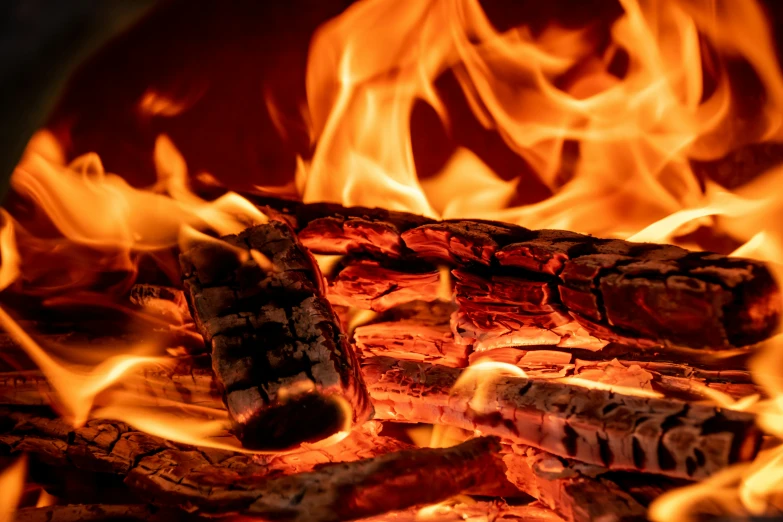 fire blazing brightly through a fireplace with a grill