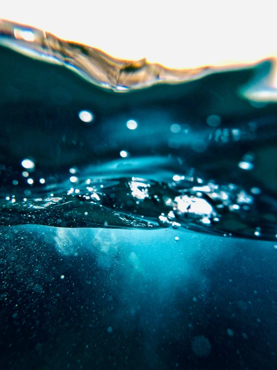 an underwater view of water's bubbles and sand