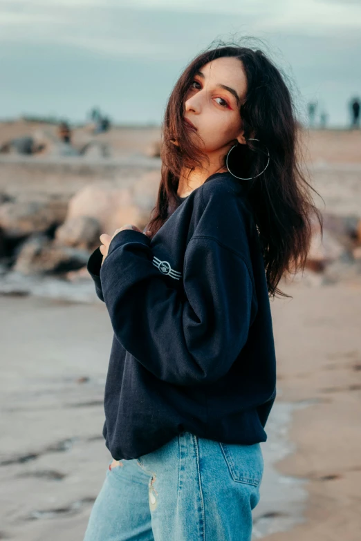 woman standing in water on beach with long hair