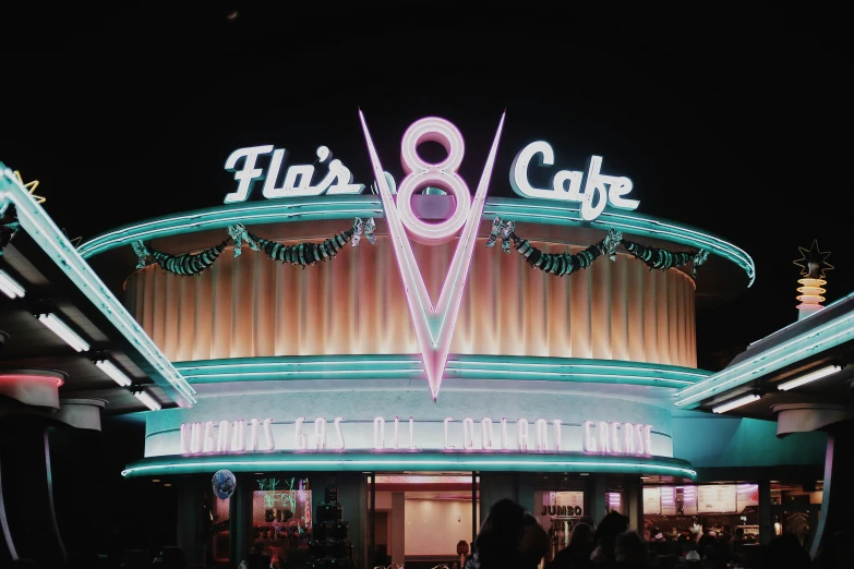 a building with many lights and a large pink sign