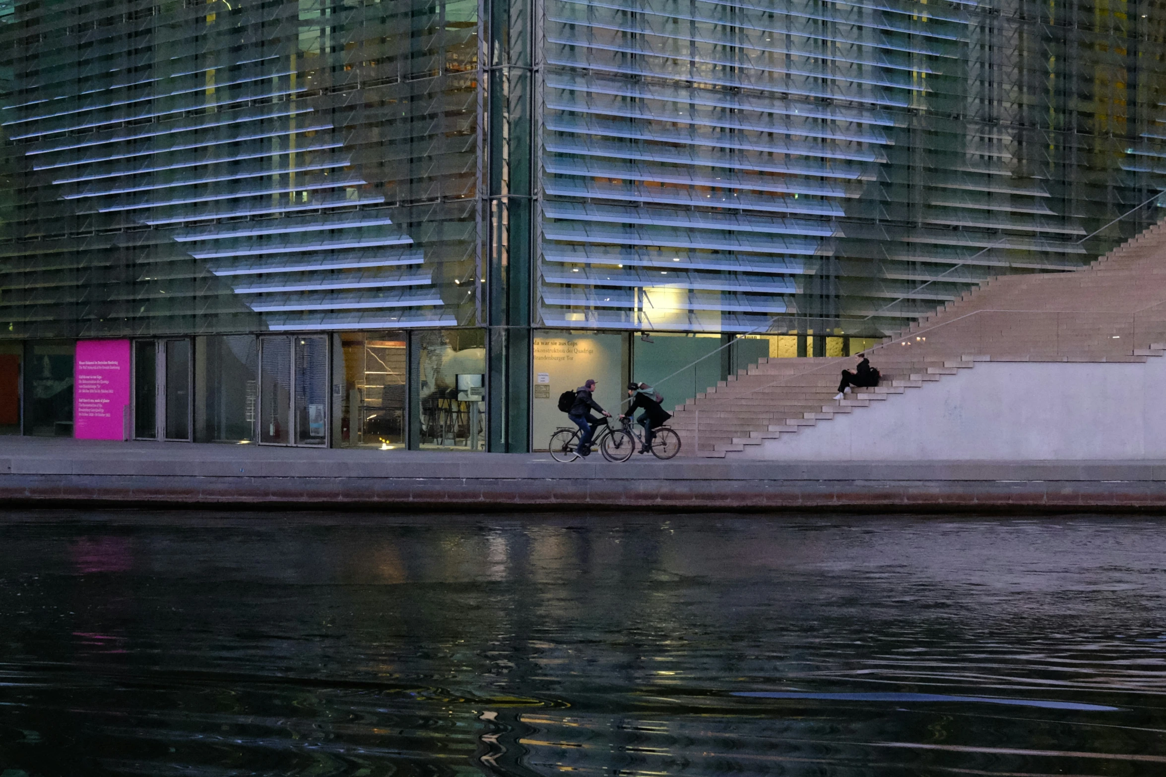 people riding bikes down the street next to tall buildings