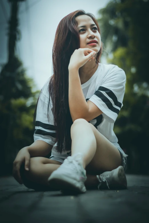 a girl sitting on the ground looking down