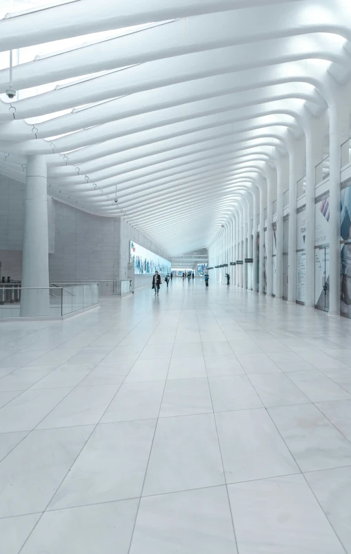 a white tiled walkway inside of a building