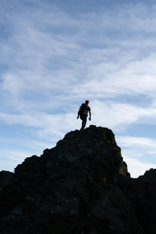 a person stands on top of a mountain and looks up